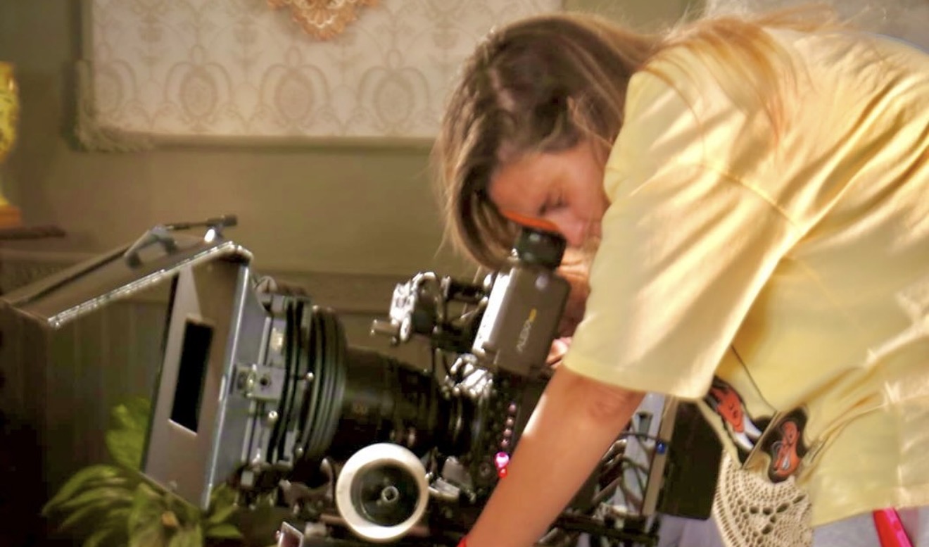 Mai Barakat looking through cinema camera viewfinder on set